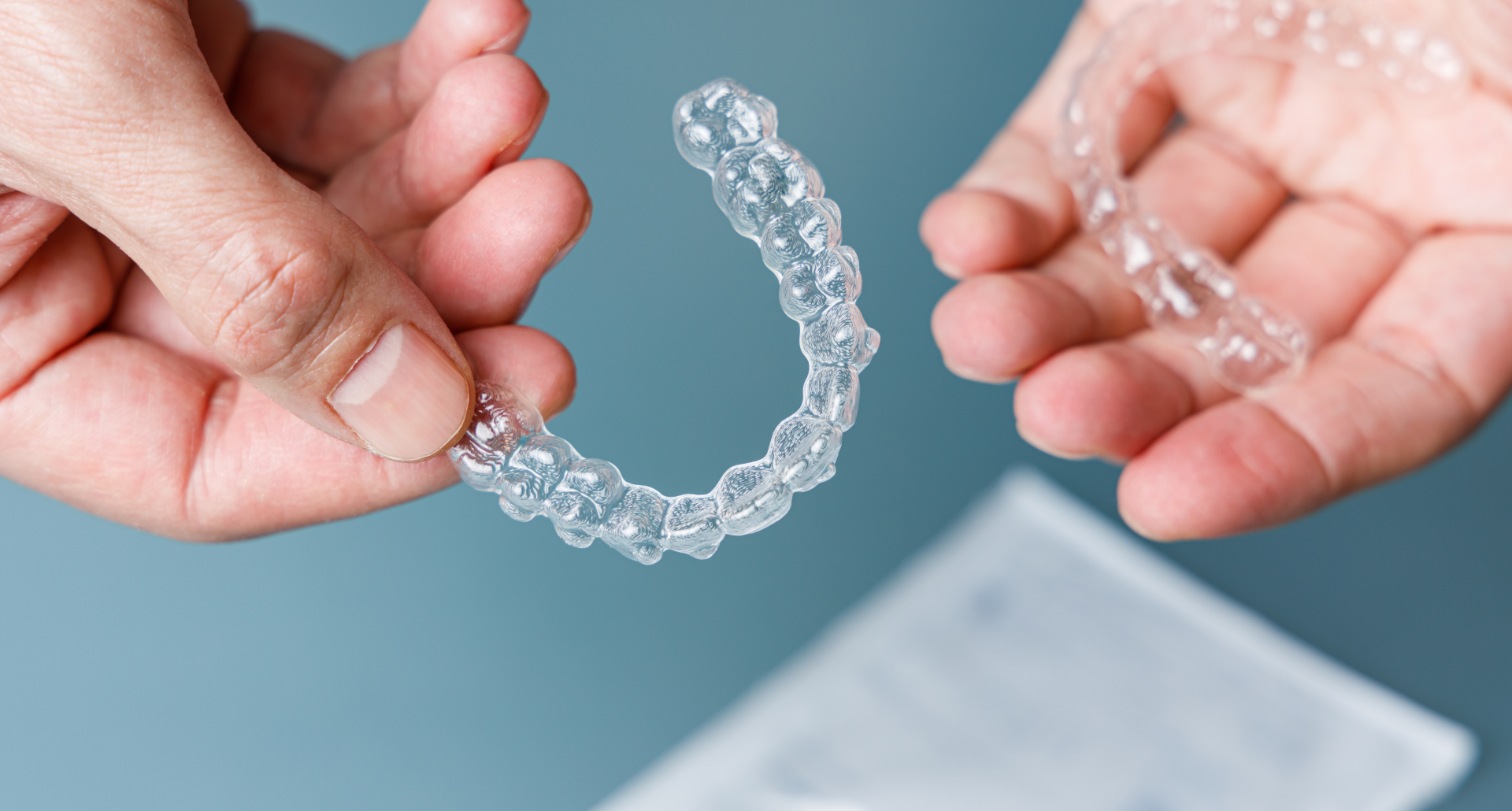 person holding a clear Invisalign aligner 