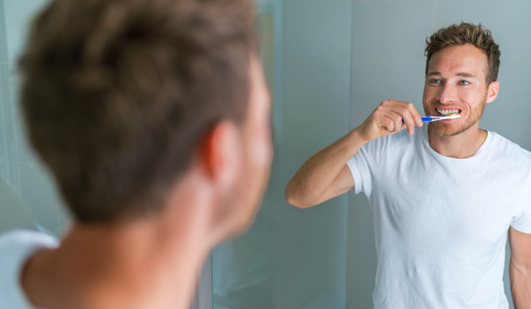 man brushing his teeth 